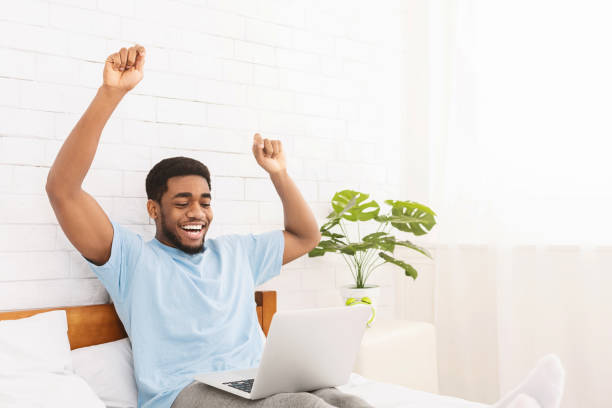African american man extremely happy working with laptop