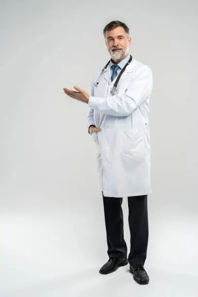 Doctor senior man, medical professional holding something in empty hand isolated over white background