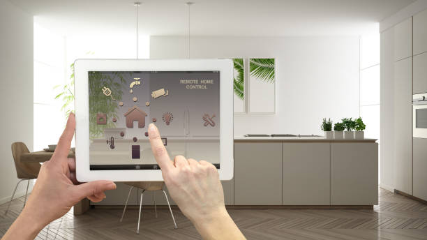 istock Smart remote home control system on a digital tablet. Device with app icons. Minimalist modern bright kitchen in the background, architecture interior design 1161346869