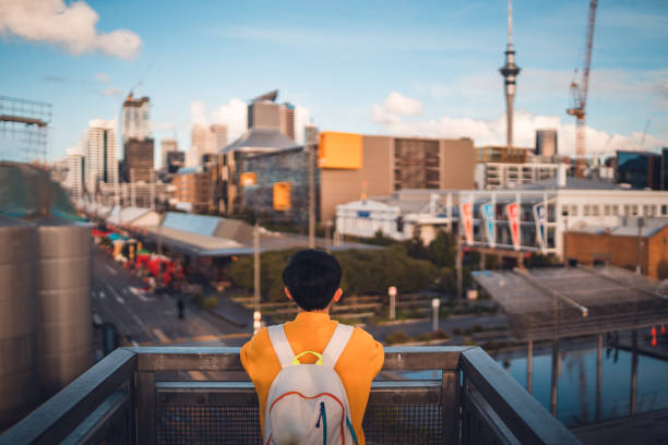 Woman with backpack enjoying Auckland city view.