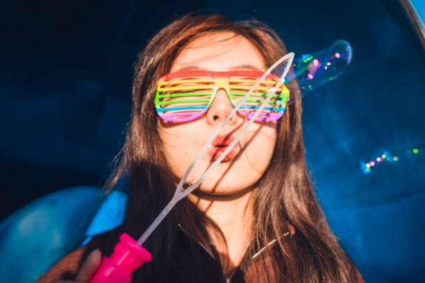 istock Female with rainbow glasses on having fun blowing bubbles. 1161346956