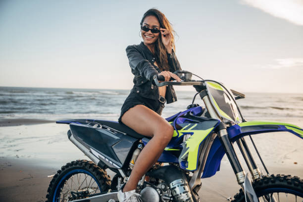 istock Charming woman sitting on motorcycle on the beach 1161350560