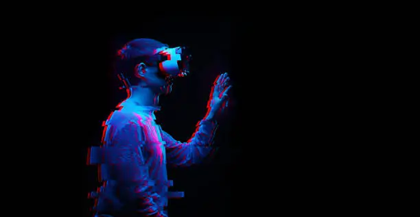 Man is using virtual reality headset. Image with glitch effect. Concept of virtual reality, simulation, gaming and future technology.