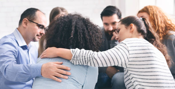 istock Addicted people comforting upset woman at therapy session 1161351630