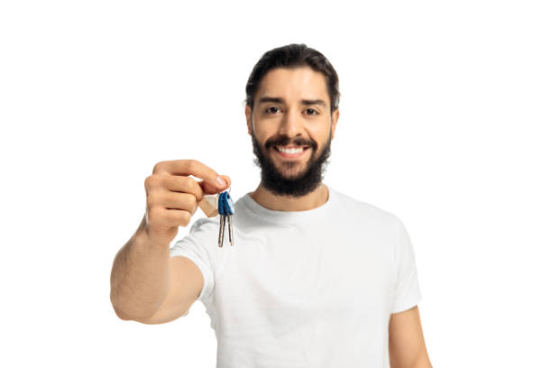 istock bearded latin man holding key and smiling isolated on white 1161352151