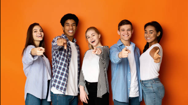 istock Happy school friends pointing fingers at camera 1161352541