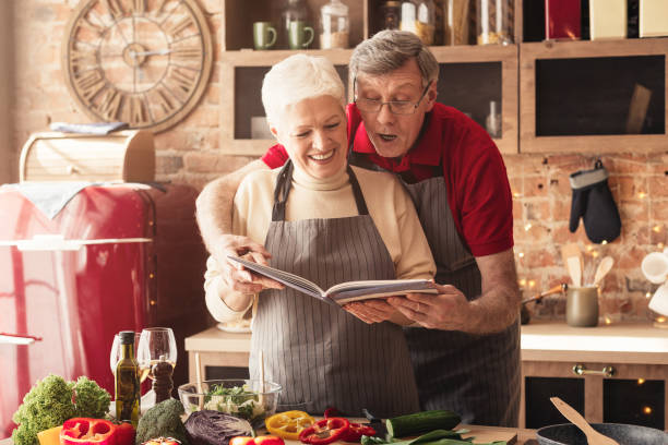 istock Senior couple preparing lunch with recipe book 1161353409