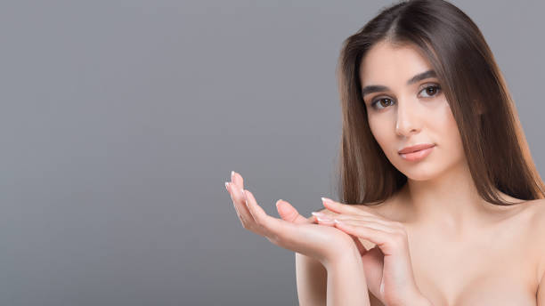 istock Young beautiful woman massaging her palms, grey background 1161353587