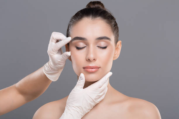 cosmetólogo examinando las arrugas faciales en la cara de la mujer joven - wrinkle treatment fotografías e imágenes de stock