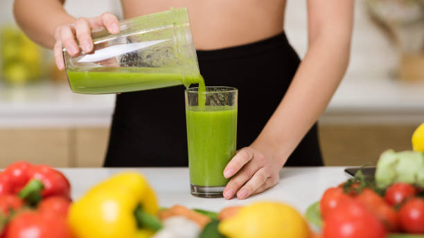 zdrowe odżywianie. kobieta wylewająca koktajl detoksykacyjny do szkła - juice glass healthy eating healthy lifestyle zdjęcia i obrazy z banku zdjęć