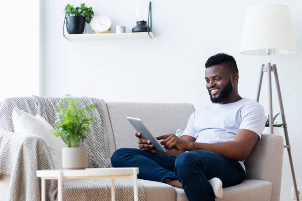 istock African-american man using digital tablet at home 1161354505
