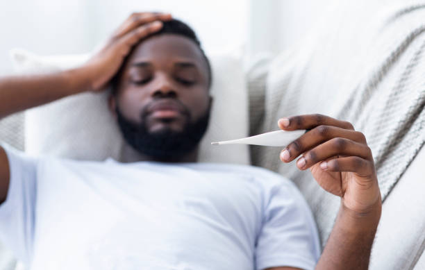 istock Sick black man checking his temperature at home 1161354578