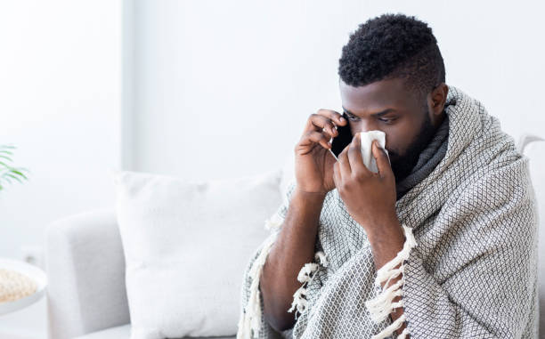 istock Sick black guy calling an ambulance, caught flu 1161354583