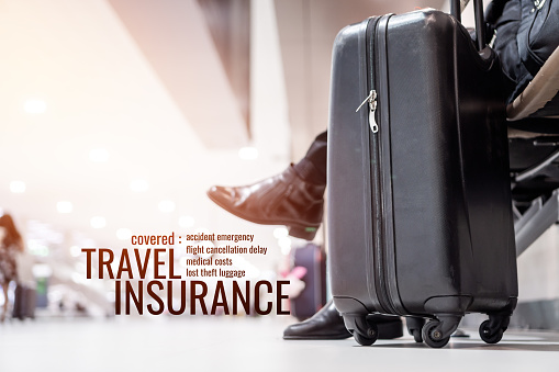 Travel Insurance concept: Suitcases at airport departure lounge traveler with word 