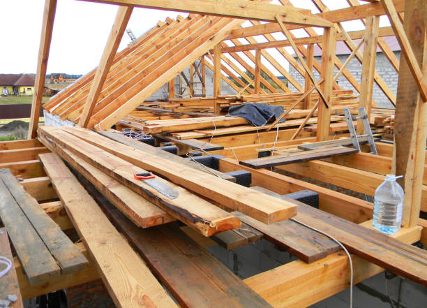 istock House roofing construction panorama. Installing wooden rafters, eaves, waterproofing logs with bitumen and timber. 1161355997