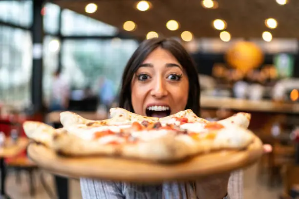 Waitress showing carnevale pizza, Neapolitan style