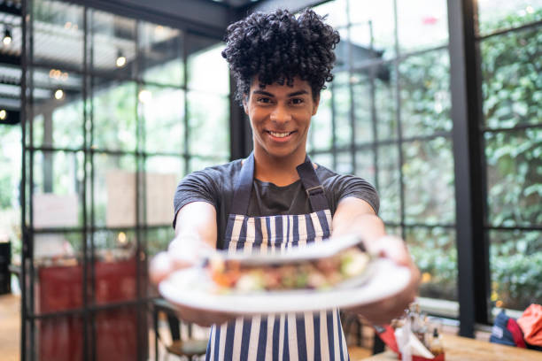 istock Waiter showing plate with a vegetarian wrap 1161358758
