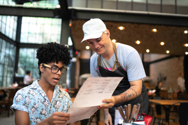 istock Waiter giving suggestions on the menu to a customer in a restaurant 1161358852