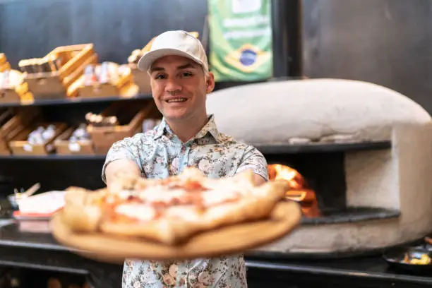 Waiter showing carnevale pizza, Neapolitan style