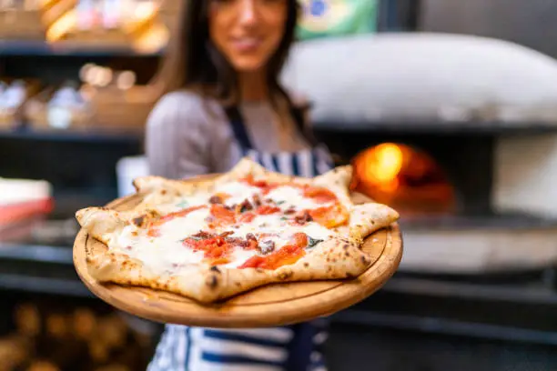 Waitress showing carnevale pizza, Neapolitan style