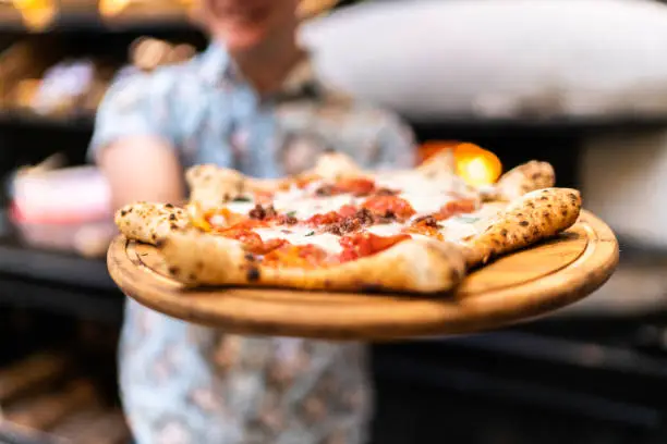 Waiter showing carnevale pizza, Neapolitan style