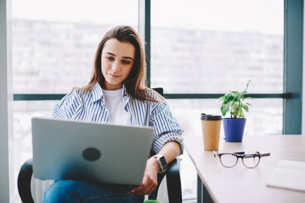istock Serious brunette woman watching video on laptop computer analyzing information for review sitting at desktop,skilled female blogger checking content in social networks using netbook and wifi in office 1161359580