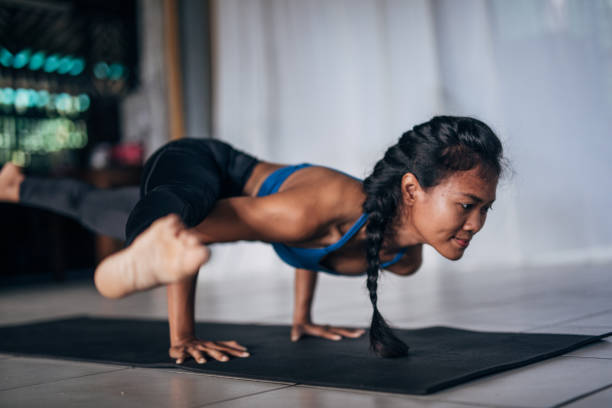 istock Young woman doing yoga on exercise mat 1161359763