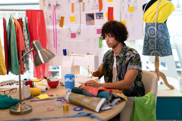 istock Male fashion designer using sewing machine on a table 1161359777