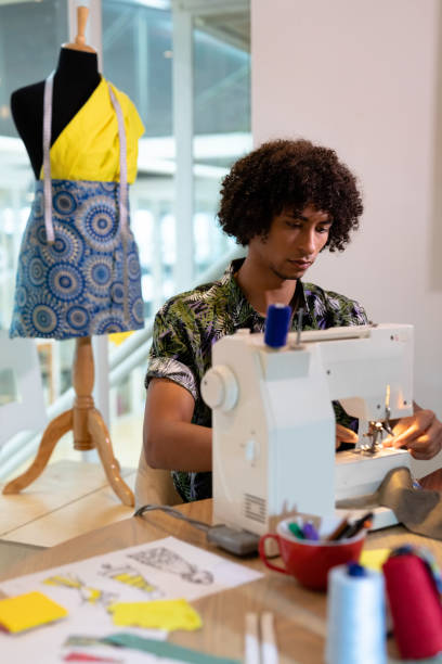 istock Male fashion designer using sewing machine on a table 1161360948