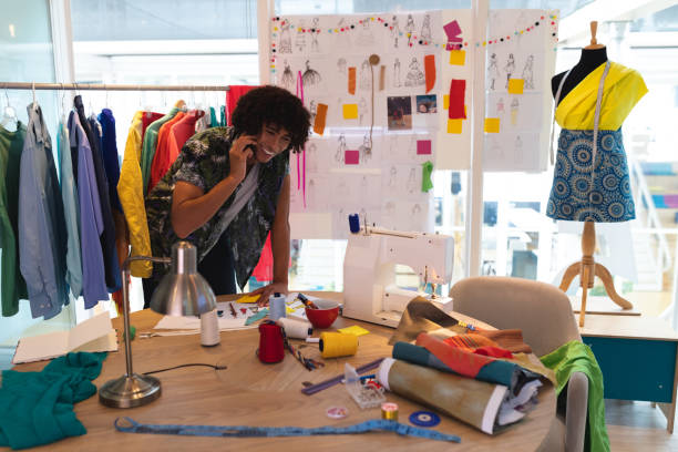 istock Male fashion designer talking on mobile phone while working on a table 1161361530