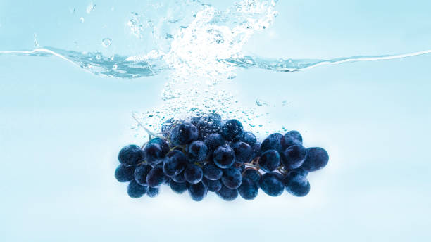 Ripe grapes falling deeply under water with big splash