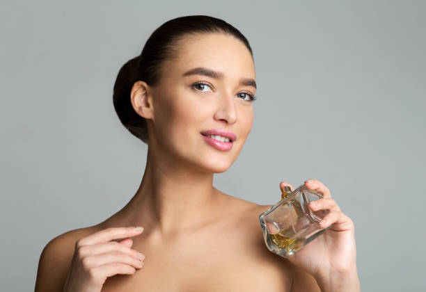 istock Woman Holding Perfume Bottle and Looking at Camera 1161363898