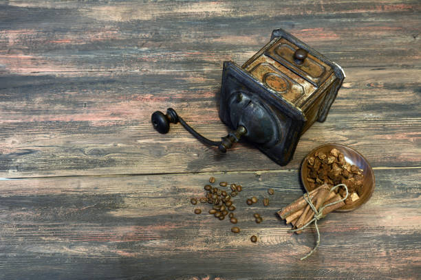 Old metallic copper coffee grinder on the wooden table background