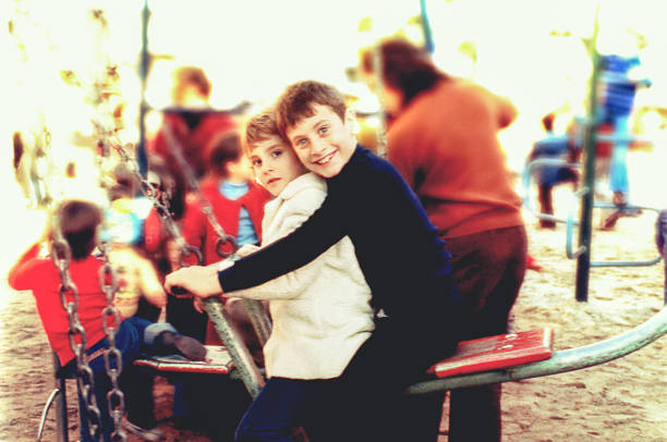 vintage foto von kindern spielen in einem spielplatz - big brother stock-fotos und bilder