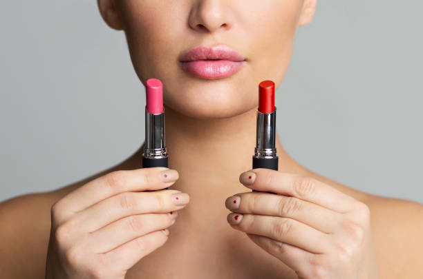 istock Woman Choosing Between Two Lipstick Colors, Doing Makeup 1161365511
