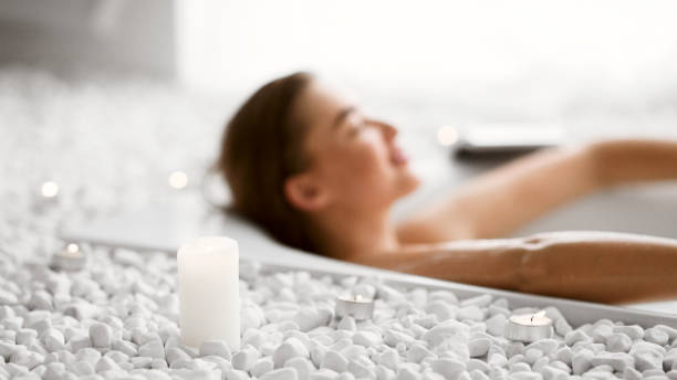 istock Young Woman Relaxing In Bath With Candles 1161366884