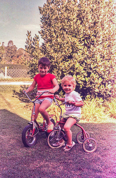 Vintage kids riding outdoors Vintage photo of little children riding in nature. brother photos stock pictures, royalty-free photos & images