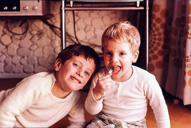 Vintage kids posing to camera Vintage photo of a couple of brothers at home. brother photos stock pictures, royalty-free photos & images