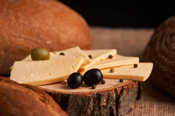 istock Slices of cheese on wooden desk between different breads. place for text 1161367770