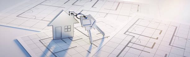 Silver toy house key chain with keys on floor plans Silver Keychain with house symbol and two keys on a floor plan drawing in sunlight floor plan blueprint stock pictures, royalty-free photos & images