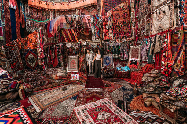 man and woman in the store. couple in love in turkey. man and woman in the eastern country. gift shop. a couple in love travels. persian shop. tourists in store. oriental carpet. istanbul. cappadocia - típico oriental imagens e fotografias de stock