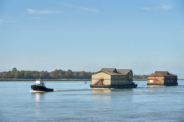 A tugboat tows fishcamp lodges to their remote destination on the BC coast