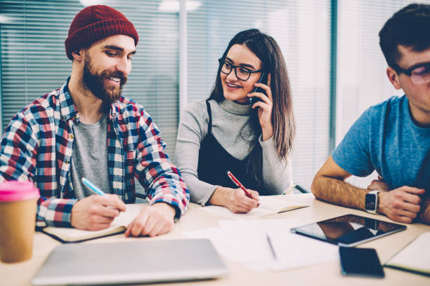 istock Positive colleagues dressed in casual wear laughing while collaborating on project in office.Successful young woman calling on smartphone and cooperating with smiling male employee while making notes 1161376007