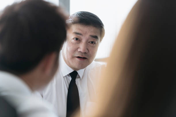 istock Mature Asian Business Executive Interacting With Colleagues 1161376287