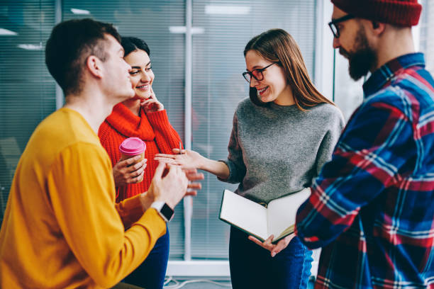 istock Positive hipster students in casual wear laughing while discussing funny story during break in office.Team of successful male and female designers collaborating with each other during brainstorming 1161377342