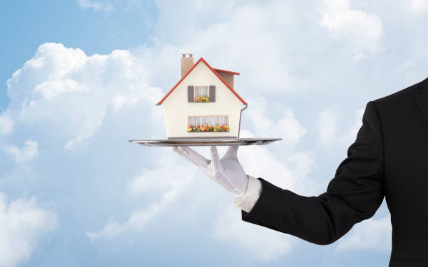 istock Businessman offering house model on silver tray 1161378090