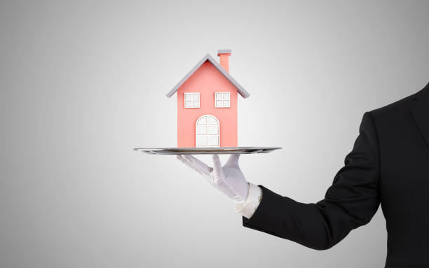 istock Businessman offering house model on silver tray 1161378093