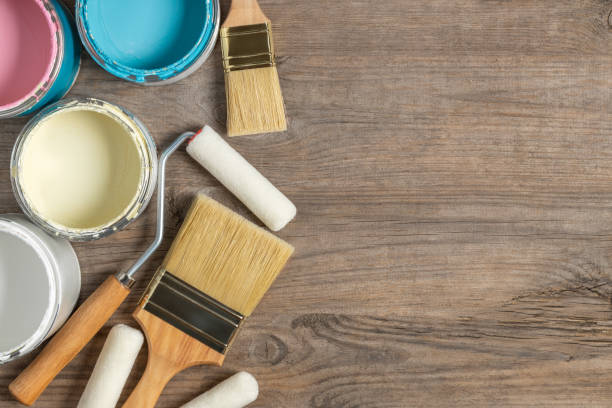 istock Paint brush and cans on wooden table 1161378569