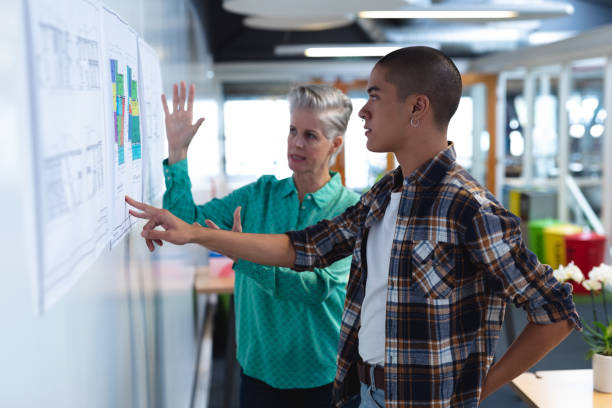 istock Male and female architects discussing over an architectural plan in office 1161381676