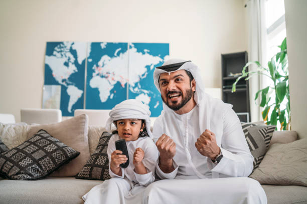 istock Arab man looking TV at home during a sport event with his son 1161386332
